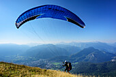 Gleitschirmflieger startet am Mittelstaufen, Bad Reichenhall im Tal, Mittelstaufen, Chiemgauer Alpen, Oberbayern, Bayern, Deutschland