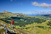 Frau beim Wandern mit Schlern und Seiseralm im Hintergrund, Friedrich-August-Weg, Langkofelgruppe, Dolomiten, UNESCO Weltnaturerbe Dolomiten, Trentino, Italien