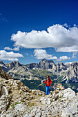 Woman hiking ascending towards Vallaccia, Rosengarten range in background, Vallaccia, Vallaccia range, Marmolada, Dolomites, UNESCO World Heritage Dolomites, Trentino, Italy