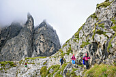 Several persons descending through valley Val Canali, rock spires in background, Rifugio Pradidali, Pala range, Dolomites, UNESCO World Heritage Dolomites, Trentino, Italy