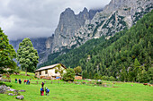Several persons hiking towards alpine hut, valley Val Canali, Pala range, Dolomites, UNESCO World Heritage Dolomites, Trentino, Italy