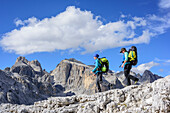 Two women hiking on rocky path, Cimon della Pala and Cima della Vezzana in background, Pala range, Dolomites, UNESCO World Heritage Dolomites, Trentino, Italy