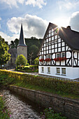 Fachwerkhaus und Kirche im Dorf Kirchveischede, bei Lennestadt, Rothaargebirge, Sauerland, Nordrhein-Westfalen, Deutschland