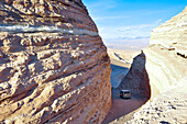 Jeep drives through canyon, Valle de la Luna, Valley of the moon, Atacama desert, National Reserve, Reserva Nacional Los Flamencos, Region de Antofagasta, Andes, Chile, South America