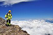 Mountain climber with ice axe over the clouds, volcano Villarrica, Strato volcano, sunset, National Park Villarrica, Pucon, Región de la Auracania, Region Los Rios, Patagonia, Andes, Chile, South America