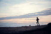 A woman runs at sunrise on Cadillac Mountain, Maine.