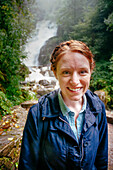 Woman at Tork waterfall in Killarney national park.