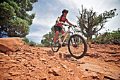 Woman rides the Submarine Rock Loop in South Sedona, Arizona. The trail has everything from slickrock to single track to stairs that lead to Submarine Rock.