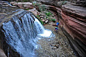 Hikers past small waterfalls along  Deer Creek Narrows in the Grand Canyon outside of Fredonia, Arizona November 2011.  The 21.4-mile loop starts at the Bill Hall trailhead on the North Rim and descends 2000-feet in 2.5-miles through Coconino Sandstone to