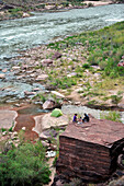 Hikers cook dinner on a cliff-pinched patio above camp and the Colorado River near Deer Creek Falls in the Grand Canyon outside of Fredonia, Arizona November 2011.  The 21.4-mile loop starts at the Bill Hall trailhead on the North Rim and descends 2000-fe