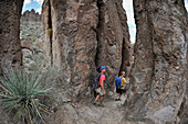 Man and woman backpackers explore the rock formations at Fremont Saddle on the popular Peralta Trail in the Superstition Wilderness Area, Tonto National Forest near Phoenix, Arizona November 2011.  The trail offers spectacular views of Weavers Needle and 