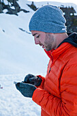 A climber checks his e-mail on his smartphone while camping in the mountains of British Columbia, Canada.