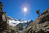 A male hiker climbs a rocky passage, named Kapruner Torl, during the Glocknerrunde, a 7 stage trekking from Kaprun to Kals around the Grossglockner, the highest mountain of Austria.     Located in the heart of the Hohe Tauern National Park which contrasts