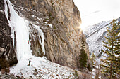 A team of ice climbers climbing on Blodgett Falls in the Bitterroot Mountains, Montana.