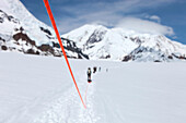 A team of mountaineers are roped up while crossing the lower Kahiltna glacier on their way to 12.000 feet camp Mount McKinley in Alaska. The rope will prevent a climber from falling deep into a crevasse when a snow bridge suddenly collapses. The other tea