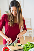 Caucasian woman slicing vegetables for salad