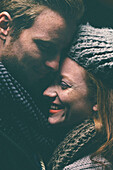 Smiling couple wearing warm clothing hugging