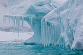 Wind and water sculpted iceberg with icicles at Booth Island, Antarctica, Polar Regions