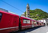 The Bernina Express train passes near the Sanctuary of Madonna di Tirano, not far from the Swiss border, on the UNESCO World Heritage Site railway, Lombardy, Italy, Europe