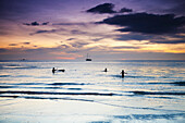 Swimming in the ocean at sunset at Cenang beach, Langkawi, Malaysia