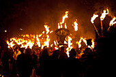 People marching along road for the East Hoathly Bonfire night, East Sussex, England