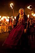 Finely dressed woman walking in procession at East Hoathly Bonfire Night, East Sussex, England