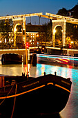 Dutch barge in front of the Skinny Bridge at dusk, Amsterdam, Holland