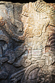'Close up of detailed stone carving of Mayan warrior holding head; Chichen Itza, Yucatan, Mexico'