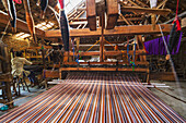 Traditional Lurik cloth being woven on a loom in a lurik workshop in Cawas village, Klaten, Central Java, Indonesia