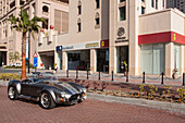 expat driving in his convertible in front of a ferrari and maserati dealership, marina of porto arabia on the man-made peninsula the pearl, doha, qatar, persian gulf, middle east