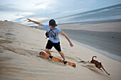 Alex Krex auf Sandboard, Duna do Por do Sol (Sunset dune), Touristen am Abend auf Duene am Strand, Jericoacoara NatPark, nahe Jericoacoara, Ceara, Brasilien