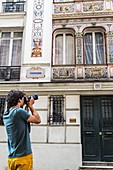 Young man taking photos of a Parisian building