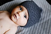 Portrait of a 9 months old baby boy wearing a bonnet