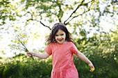 A 5 years old girl with flowers in the countryside