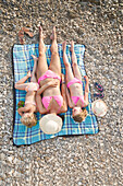 Caucasian mother and daughters sunbathing on beach