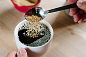 Brown Sugar Being Poured into Cup of Coffee, High Angle View