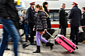 Mädchen mit Koffer läuft über den Bahnsteig im Zuggleis, München, Bayern, Deutschland, Europa