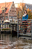 Girl on bridge with love locks, Lueneburg, Lower Saxony, Germany, Europe