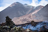 Erstarrte, dampfende Lava vor dem Südost-Krater des Etna. Dampfschwaden steigen auf, Sizilien, Italien