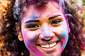 Smiling mixed race woman covered in pigment powder