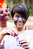 Smiling friends covered in pigment powder