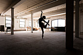 Caucasian ballet dancer performing in loft room
