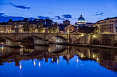 Ornate buildings and bridge illuminated at night, Rome, Italy