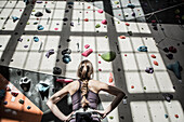 Athlete examining rock wall in gym