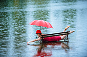 Caucasian woman laying on bench in flood