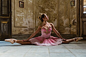 Hispanic ballet dancer posing in dilapidated mansion