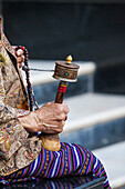 A faithful Buddhist uses the traditional portable roller-book (prayer wheel), Bhutan, Asia