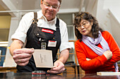 Museum of the Printing Arts Leipzig, worker and visitor at the printing machine, type foundry, Chinese characters, Leipzig, Saxony, Germany