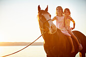 Two girls riding a quarter horse near Lake Starnberg, Upper Bavaria, Bavaria, Germany