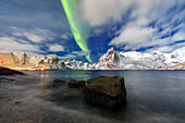 Northern Lights (aurora borealis) illuminate Hamnoy village and snowy peaks, Lofoten Islands, Arctic, Norway, Scandinavia, Europe